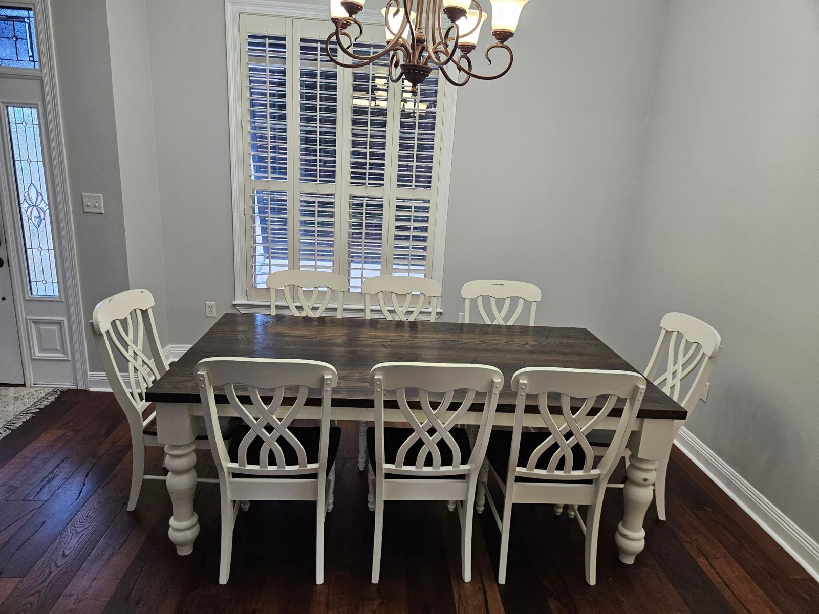 The Hernando farmhouse table with turned, painted legs and a dark stained top, set for eight